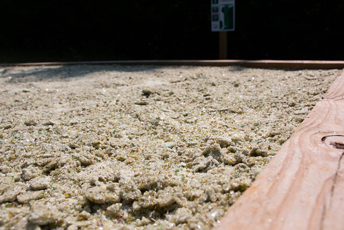 A tee boxÂ along the Thistle Ridge Disc Golf Trail using recycled glass for sand