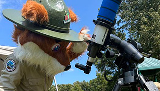 Parker Redfox looks through a telescope